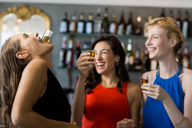 Female friends having tequila shot in restaurant