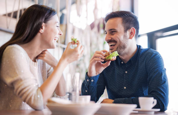 朝食を食べて、カフェに座って美しい若いカップル。愛、食品、ライフ スタイル - lunch ストックフォトと画像