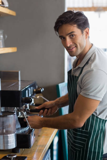 istock Waiter making cup of coffee at cafe 653811658