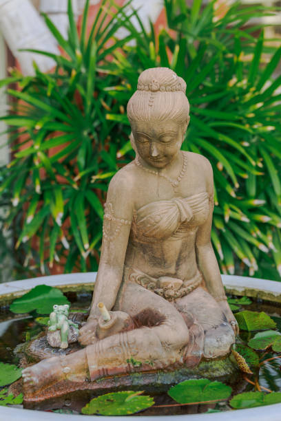 istock Thai style lady statue in big lotus pot 653812804