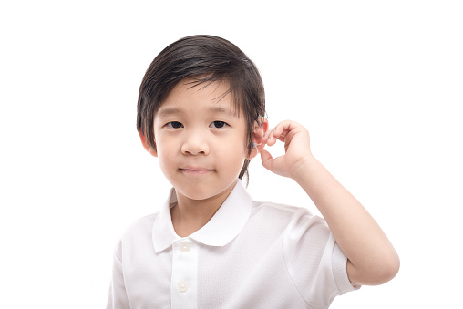 Cute Asian child with hearing aid on white background isolated