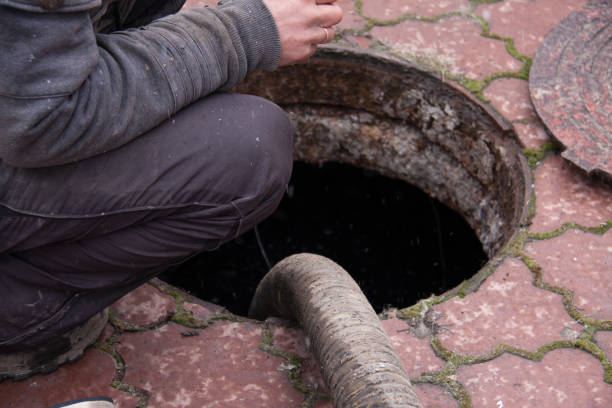 istock man pumping sewage from the drain hole 653819420