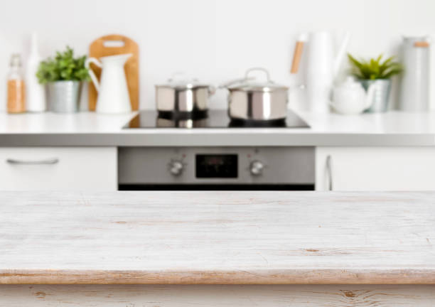 istock Bleached wooden texture table on defocused pastel color kitchen background 653819500
