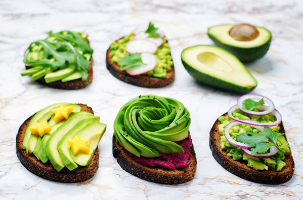 Variation of healthy rye breakfast sandwiches with avocado and toppings