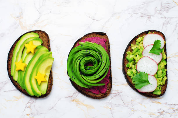 Variation of healthy rye breakfast sandwiches with avocado and toppings