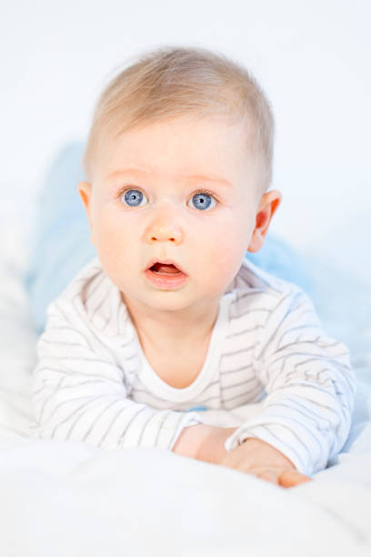 istock beautiful baby boy lying in bed on white background 653822630