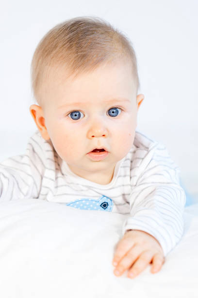 istock beautiful baby boy lying in bed on white background 653822674
