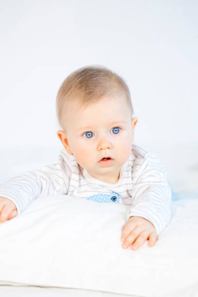 istock beautiful baby boy lying in bed on white background 653822684