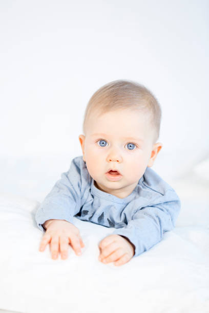 istock beautiful baby boy lying in bed on white background 653822704