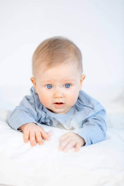 istock beautiful baby boy lying in bed on white background 653822742