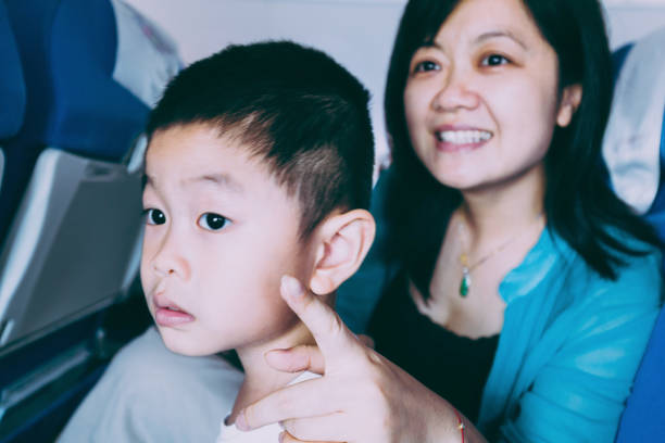 istock Mother and son talking in airplane travelling 653825766