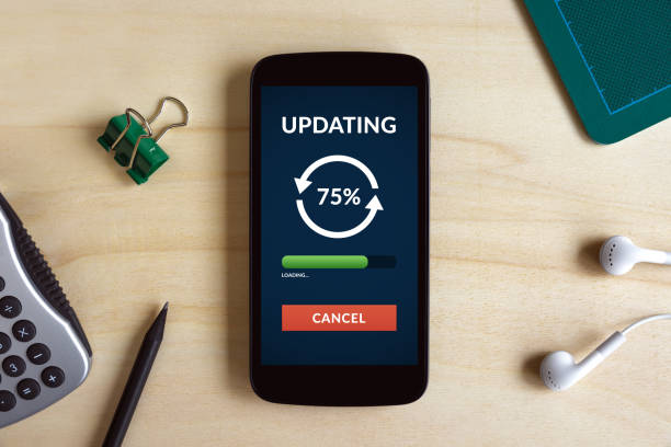 istock Update concept on smart phone screen on wooden desk 653825956