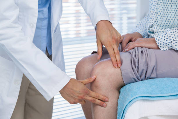 Doctor examining patient knee stock photo