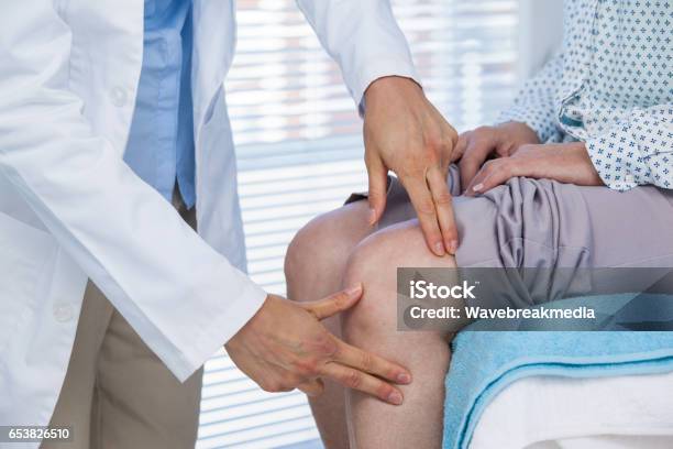 Doctor Examining Patient Knee Stock Photo - Download Image Now - Doctor, Pain, Examining