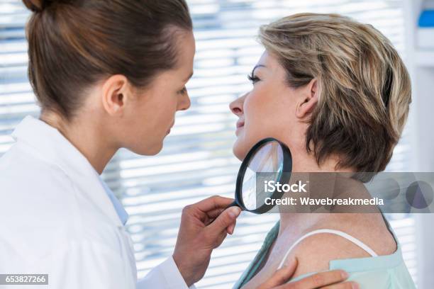 Dermatologist Examining Mole With Magnifying Glass Stock Photo - Download Image Now - Skin Cancer, Melanoma, Dermatologist