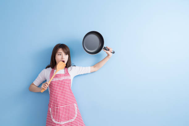 istock housewife take wok and spoon 653830104