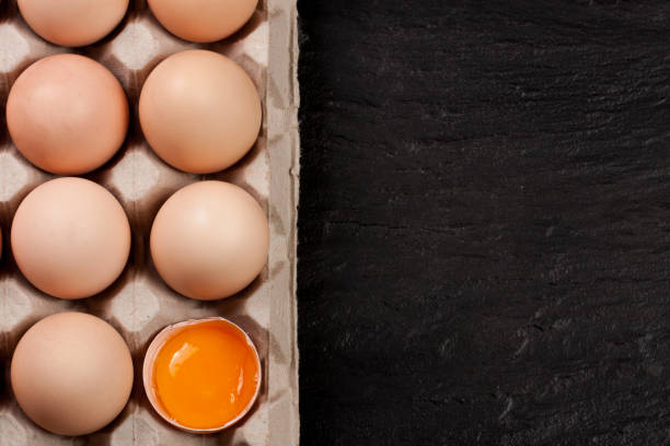 istock eggs in a tray on a dark background with copy space for your text. Top view 653830770