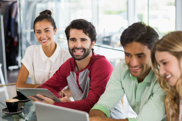 istock Group of friends using laptop while having cup of coffee 653831176