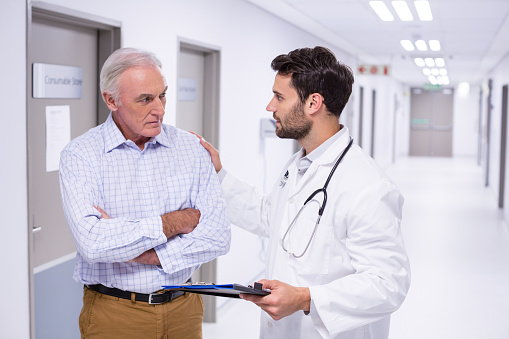 Doctor interacting with patient in corridor of hospital