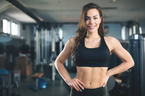 giovane atleta donna sorridente per la macchina fotografica - women weight bench exercising weightlifting foto e immagini stock