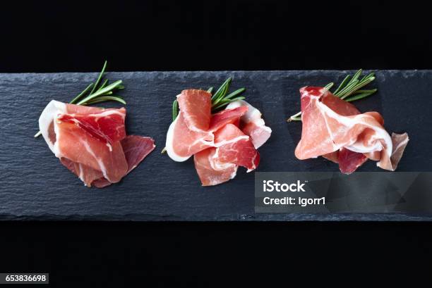 Prosciutto With Rosemary On A Black Background Stock Photo - Download Image Now - Ham, Prosciutto, Parma Ham