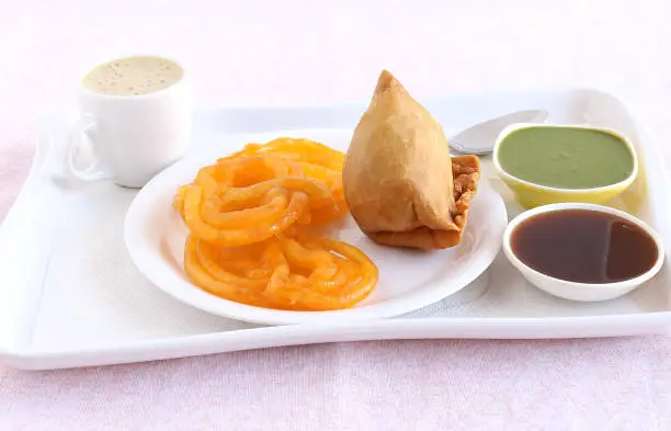 Jalebi and samosa, Indian vegetarian food with their origins in north India, and coffee and chutneys.