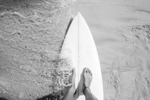 Young women standing on the surfboard Black and white photo of girl standing on the board Mentawai Islands stock pictures, royalty-free photos & images