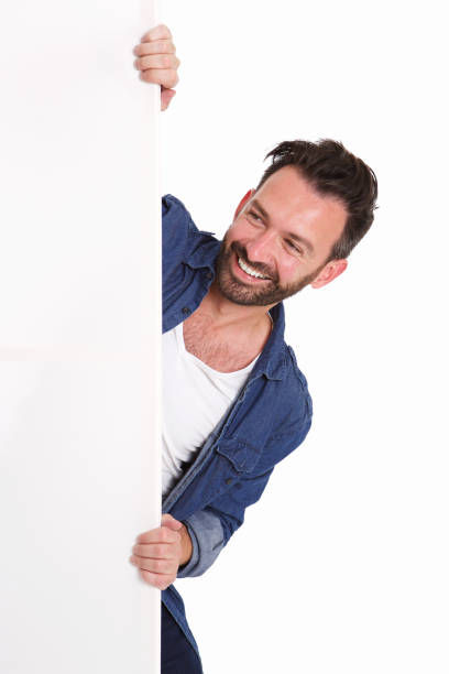 istock Happy mature man peeking over blank poster sign 653844144
