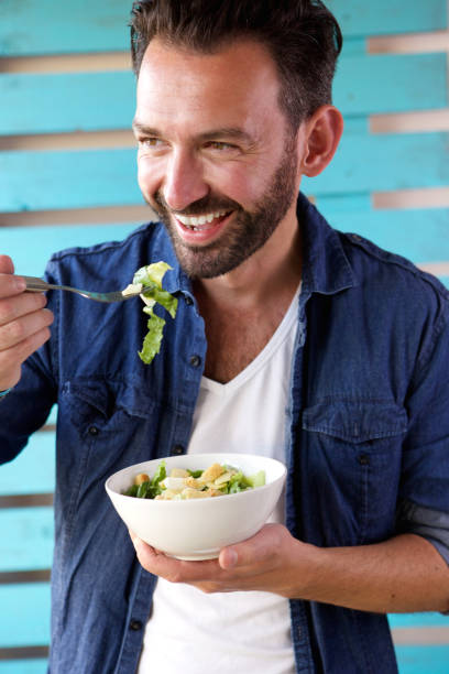 istock Mature man eating salad and smiling 653844182