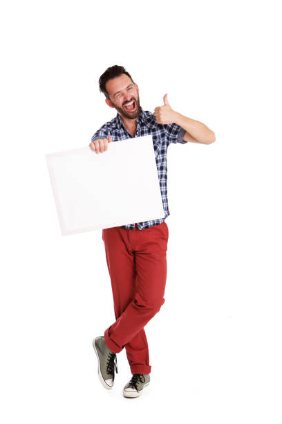 istock Cheerful man holding blank poster and showing thumbs up 653844252