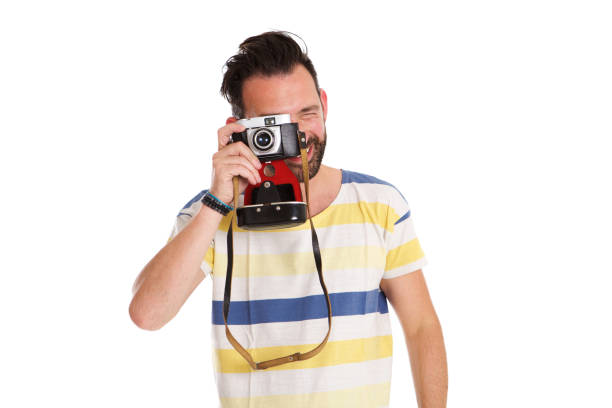 Portrait of mature man taking photo with old camera isolated over white background