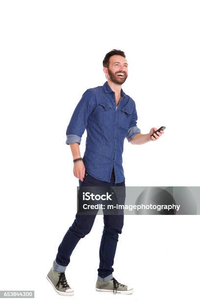Handsome Mature Man Walking With Mobile Phone And Laughing Stock Photo - Download Image Now