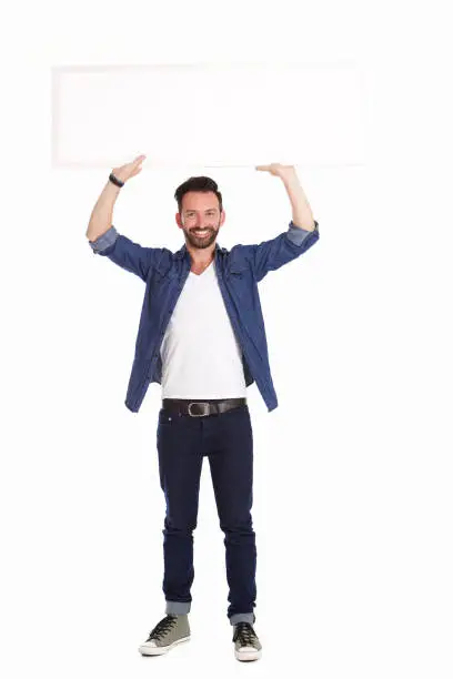Full length portrait of handsome mature man holding blank billboard over white background