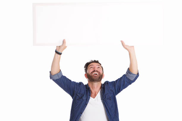 istock Mature man laughing and holding blank poster sign 653844510