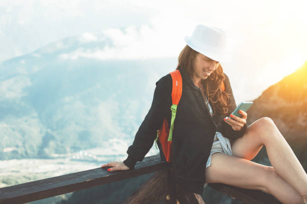 istock Woman in mountains typing message on mobile phone 653844616