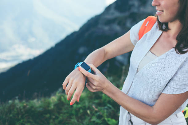 istock Woman looking at smart watch while traveling in mountains 653845132