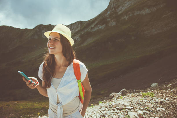 istock Woman in mountains typing message on mobile phone 653845366
