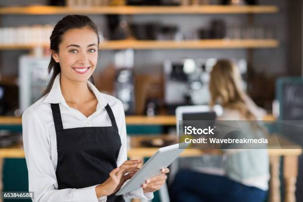 Portrait Of Smiling Waitress Using Digital Tablet Stock Photo - Download Image Now - Hotel, Restaurant, Service