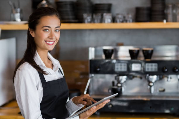 istock Portrait of smiling waitress using digital tablet 653847060