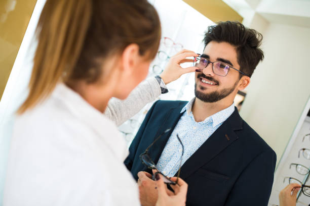 istock Young man selecting eyeglasses in optical shop 653849054