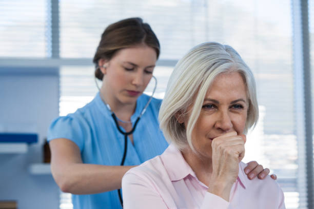 istock Doctor examining coughing patient 653851184