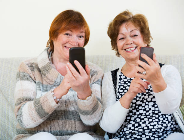 istock Cheerful mature women browsing internet on smarthphones 653851516
