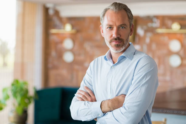 istock Confident man standing with arms crossed in restaurant 653858042