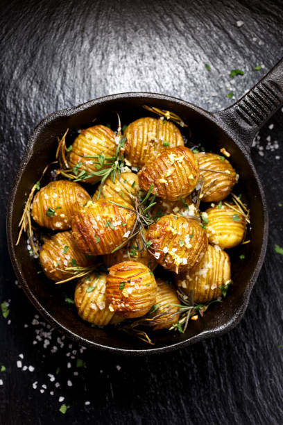 istock Rosemary and garlic roast potatoes  on a cast iron pan 653865794