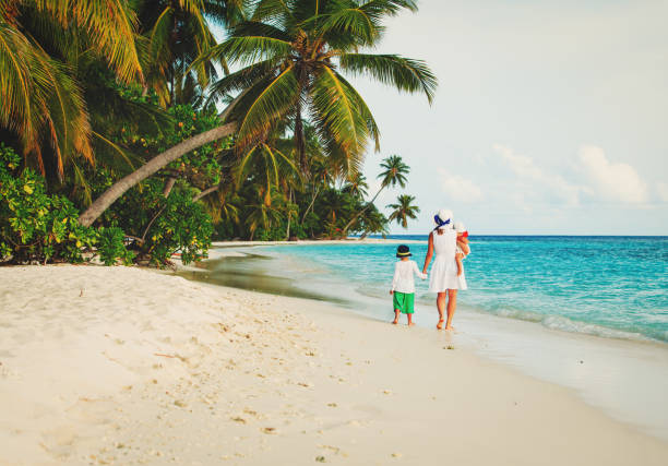 istock mother with little son and daughter walk on beach 653865870