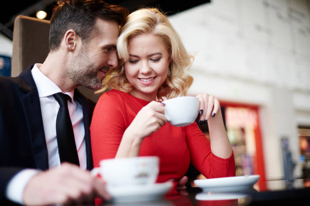 Side view of embraced couple in cafe