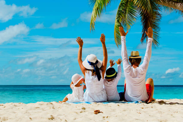 happy family with two kids hands up on beach stock photo