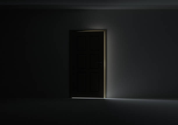 istock Open door with bright light streaming into very dark room 653869022