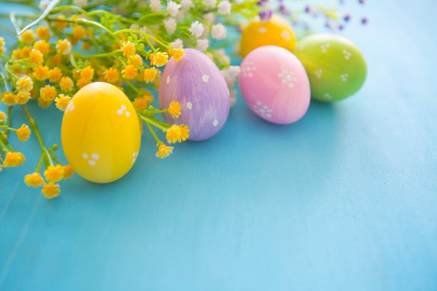 istock Easter decoration eggs and flowers on a blue wooden table background. 653869180