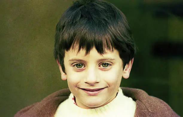 Vintage portrait of a green eyes boy  smiling at camera